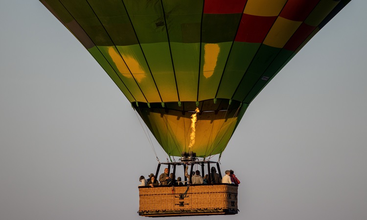 Visitor enjoying a hot air balloon ride over the Serengeti during a Five-Day Serengeti Safari, taking in panoramic views of wildlife and the breathtaking landscapes below