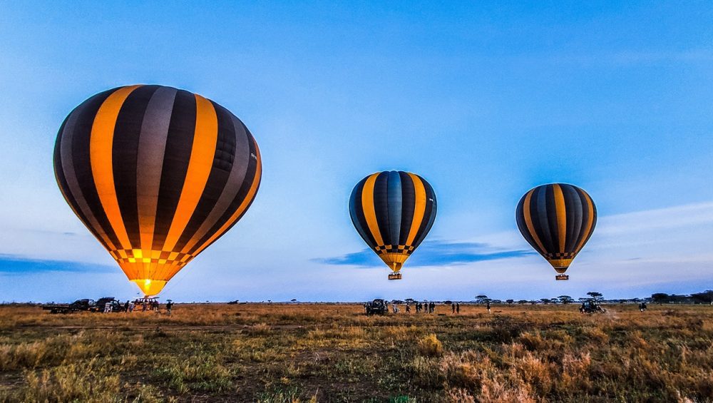 Hot air balloon soaring over the Serengeti during a Five-Day Serengeti Safari offering breathtaking aerial views of the wildlife-rich plains below.