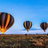 Hot air balloon soaring over the Serengeti during a Five-Day Serengeti Safari offering breathtaking aerial views of the wildlife-rich plains below.