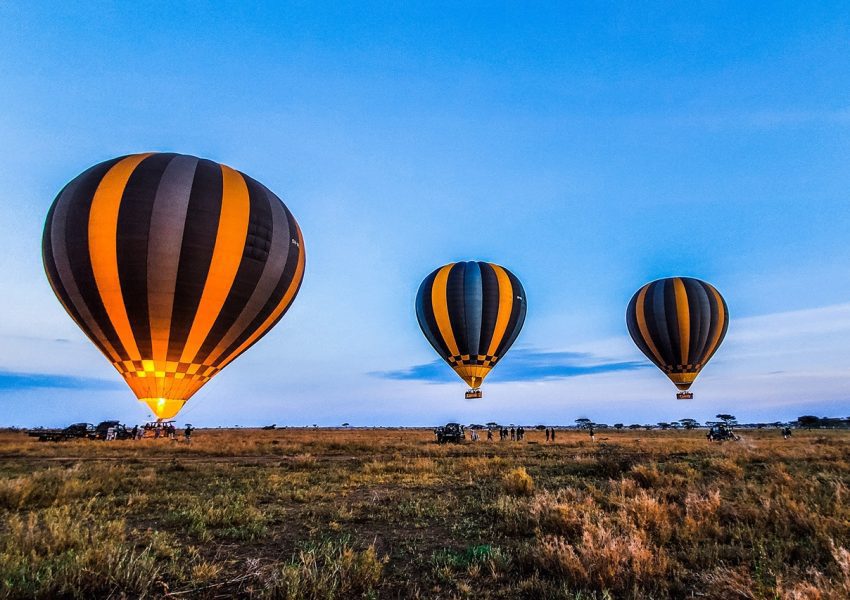 Hot air balloon soaring over the Serengeti during a Five-Day Serengeti Safari offering breathtaking aerial views of the wildlife-rich plains below.