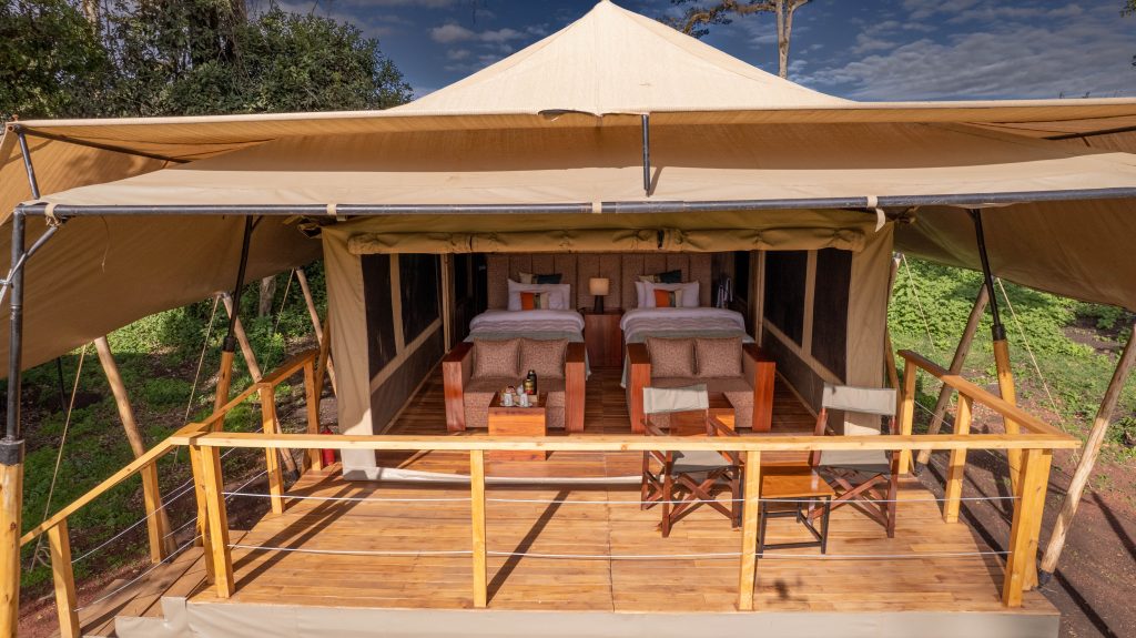 Ang'ata Camp, a rustic safari accommodation in Tanzania, featuring comfortable canvas tents with thatched roofs, set against the scenic backdrop of the Serengeti or Ngorongoro wilderness.