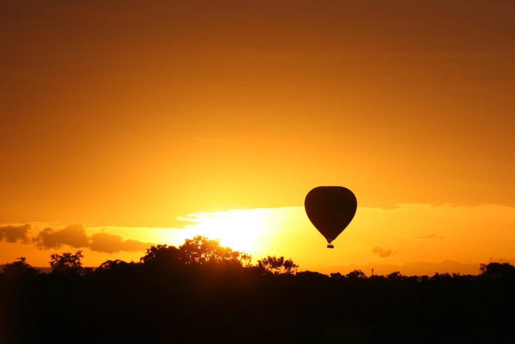 Hot air balloon safari over the Serengeti at sunrise, a bucket-list Tanzania safari experience with panoramic wildlife views.
