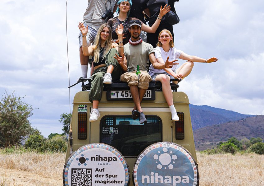 Group of travelers posing on top of a Nihapa Tours safari vehicle during a 7-Day Private Group Joining Tanzania Safari