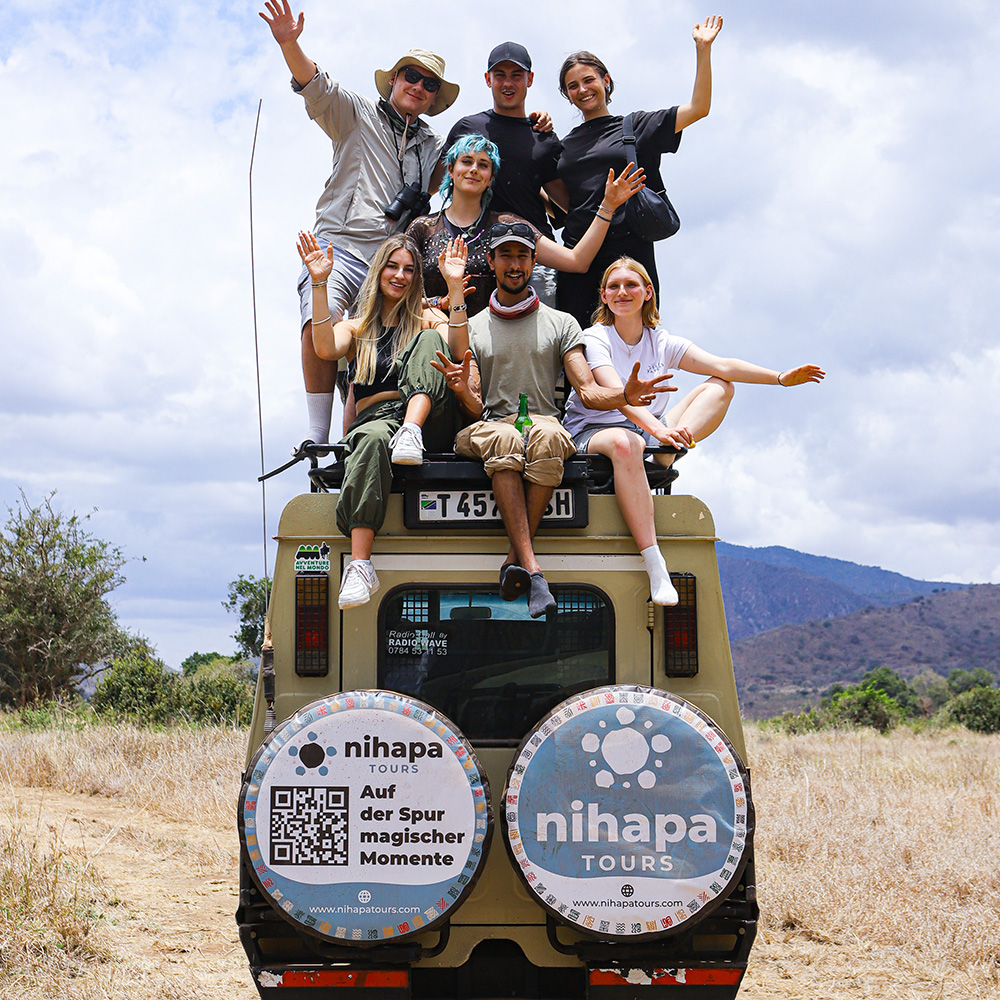 Group of travelers posing on top of a Nihapa Tours safari vehicle during a 7-Day Private Group Joining Tanzania Safari
