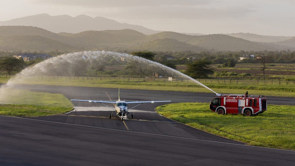 Miracle Air aircraft being welcomed with water at Arusha Airport, a trusted airline in Arusha for safari travelers.