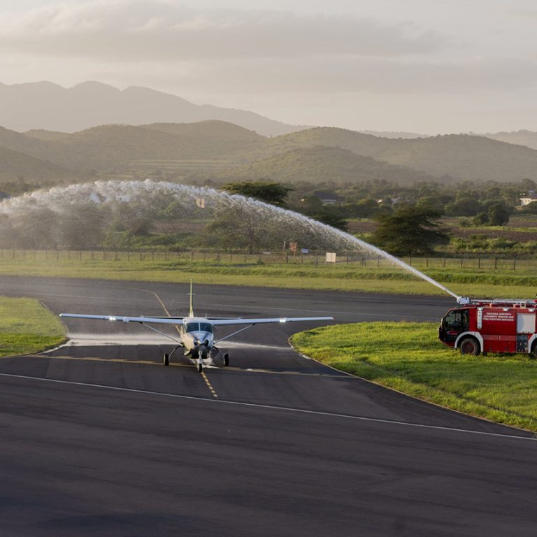 Miracle Air aircraft being welcomed with water at Arusha Airport, a trusted airline in Arusha for safari travelers.